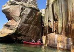 Lake Superior kayaks at the base of the towering, colorful cliffs
